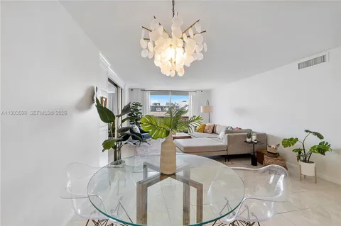 a dining room with furniture a chandelier and wooden floor