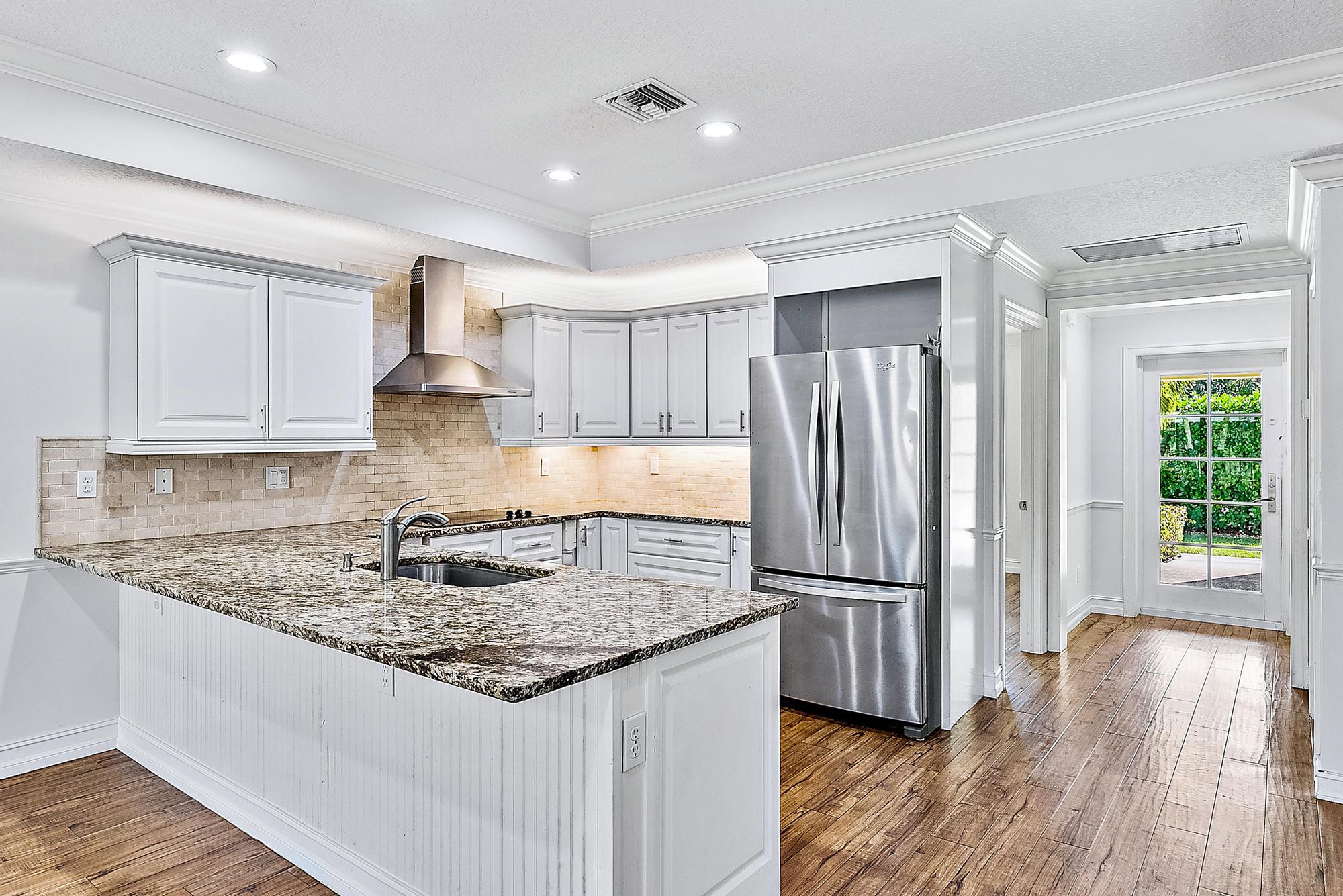5791 Roebuck Road Jupiter, FL 33458 - Photo 6 of 23 a kitchen with stainless steel appliances granite countertop a refrigerator a sink and a stove