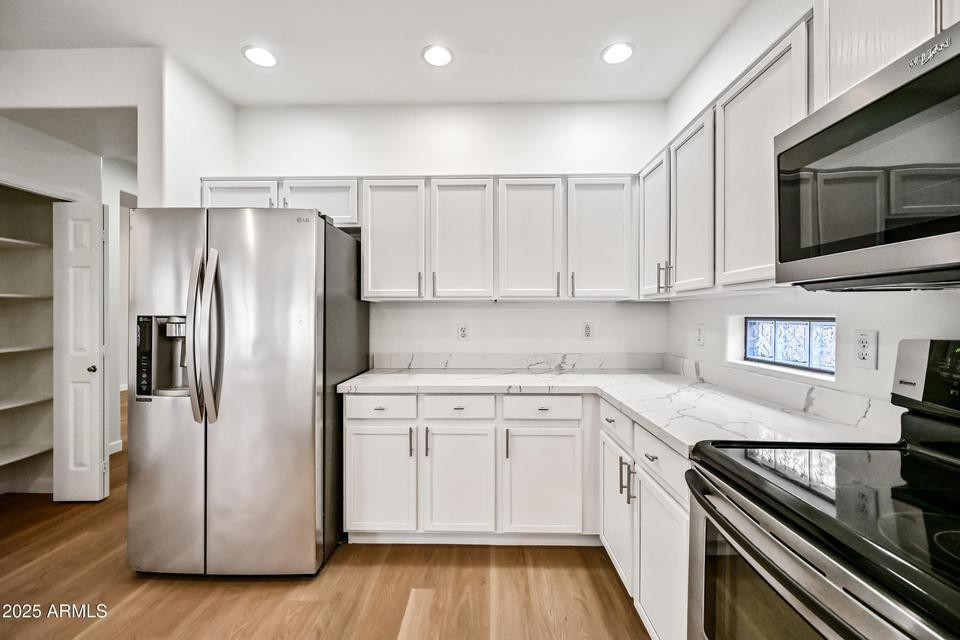 865 South Oak Street Gilbert, AZ 85233 - Photo 11 of 27 a kitchen with a refrigerator stove and white cabinets