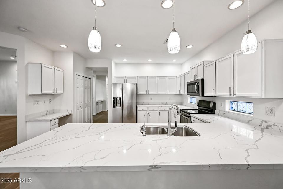 865 South Oak Street Gilbert, AZ 85233 - Photo 8 of 27 a large white kitchen with lots of counter space wooden floor and appliances