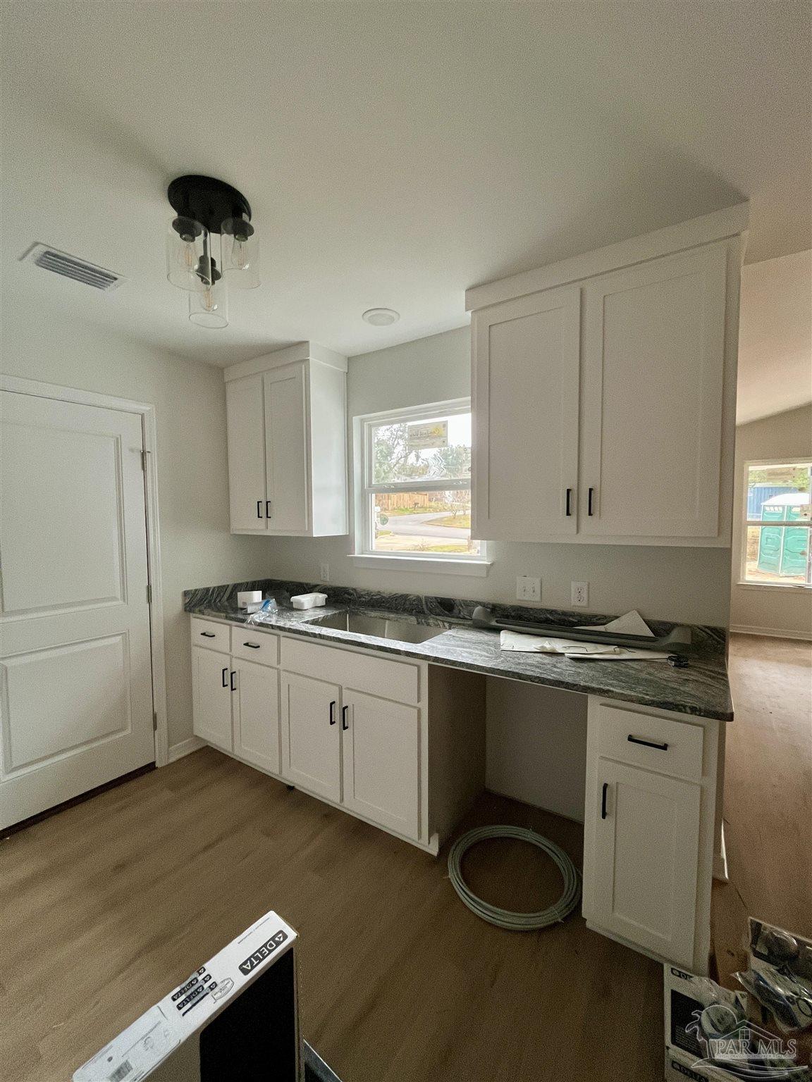 5634 Alabama Street Milton, FL 32570 - Photo 6 of 9 a kitchen with granite countertop a sink stainless steel appliances and cabinets