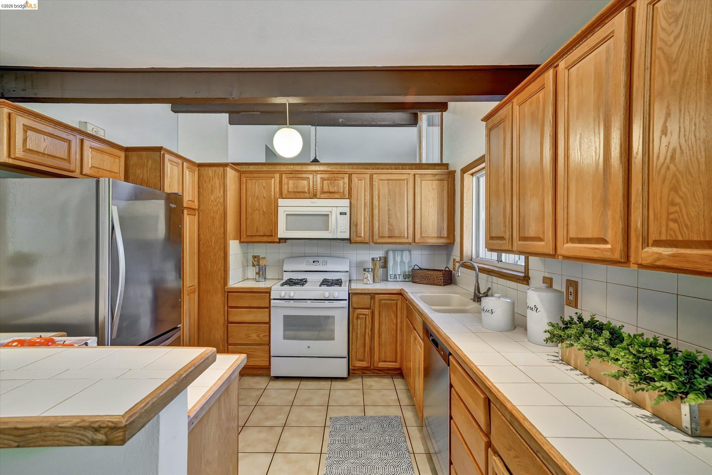 2826 Wright Avenue Pinole, CA 94564 - Photo 18 of 70 Kitchen featuring wood cabinetry, white tile countertops, and a white tile backsplash