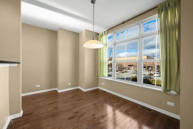 a view of a room with a large window and wooden floor