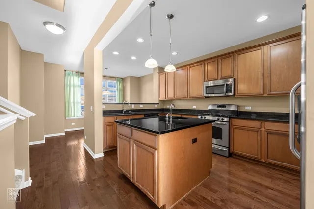 a kitchen with granite countertop a sink cabinets and stainless steel appliances