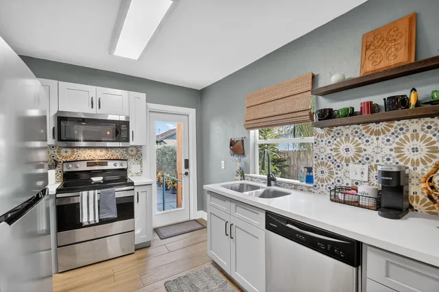 a kitchen with stainless steel appliances a sink a stove and cabinets