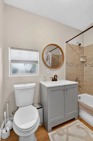 a bathroom with a toilet sink vanity tub and mirror