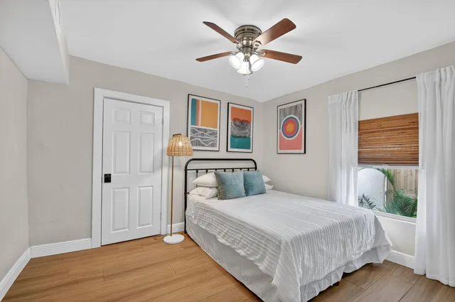 a bedroom with a large bed a chandelier and a window
