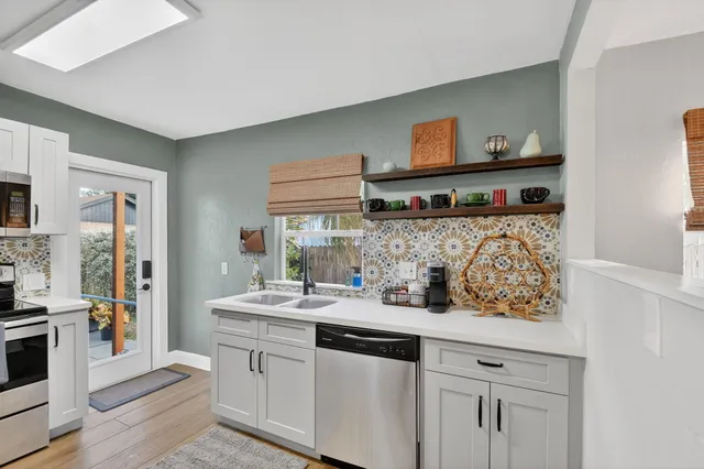 a kitchen with stainless steel appliances granite countertop a sink stove and cabinets