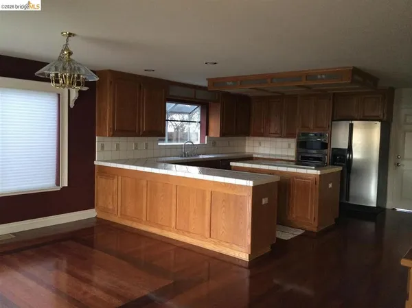 a kitchen with granite countertop a sink stainless steel appliances and cabinets