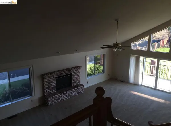 a living room with furniture a floor to ceiling window and a fireplace