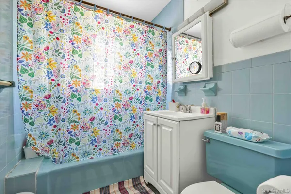 a bathroom with a sink toilet and shower curtain