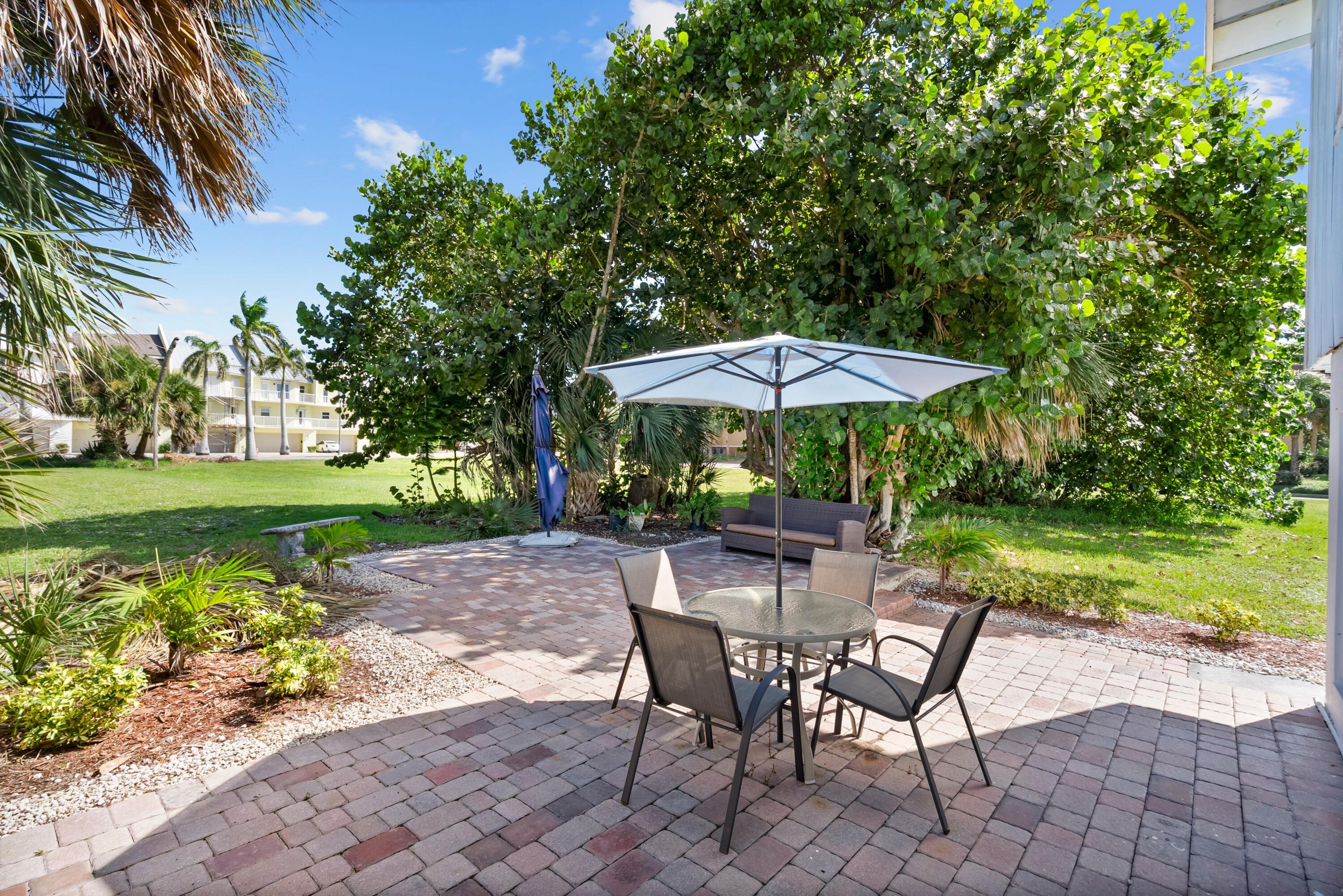 670 Hernando Street, Unit A Fort Pierce, FL 34949 - Photo 17 of 21 a view of patio with chairs and table under an umbrella