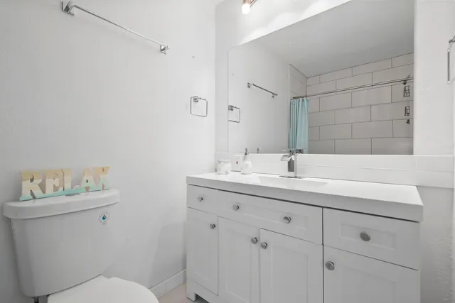 a bathroom with a sink toilet and a mirror