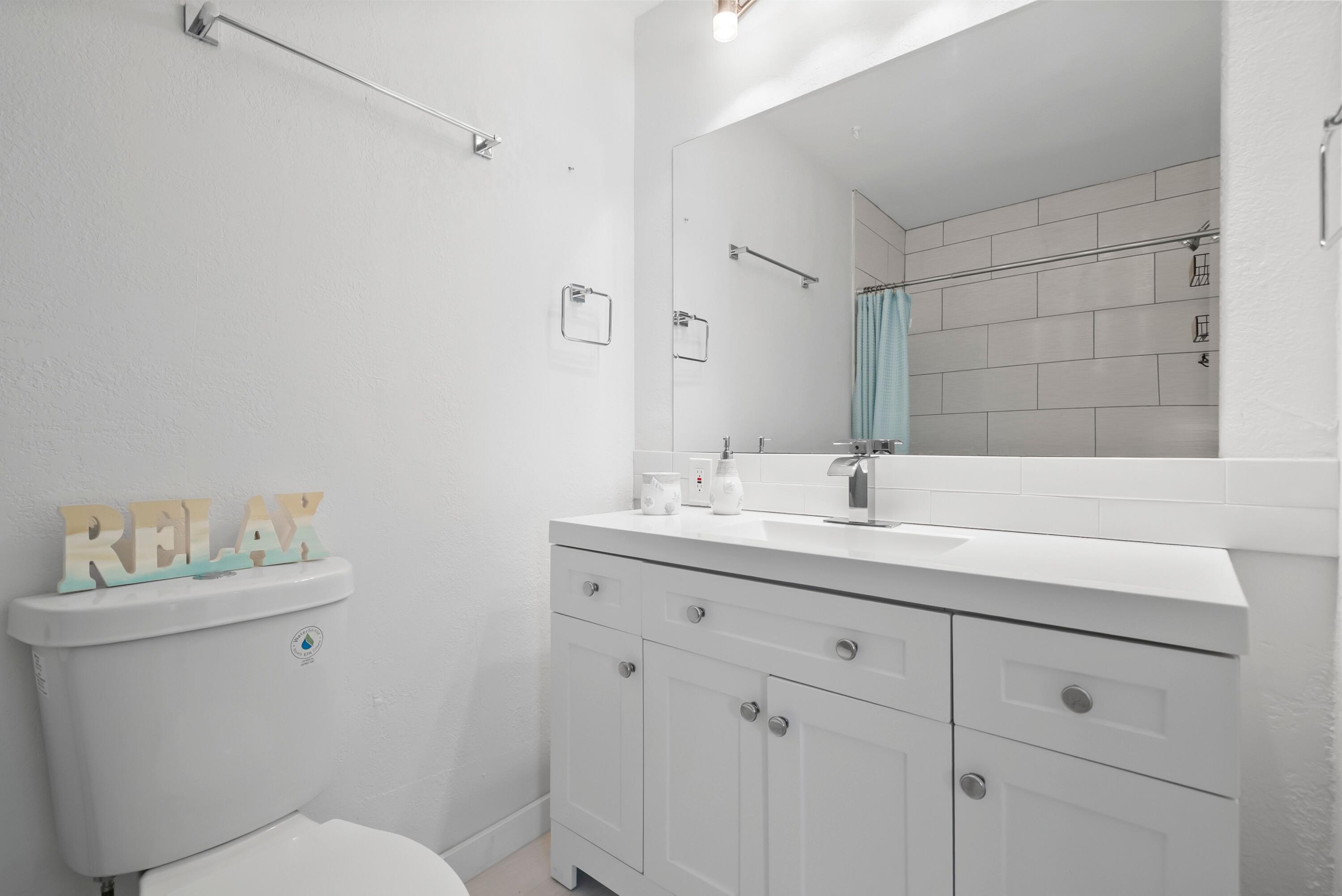 670 Hernando Street, Unit A Fort Pierce, FL 34949 - Photo 9 of 21 a bathroom with a sink toilet and a mirror