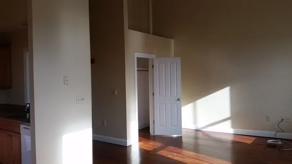 a view of empty room with wooden floor