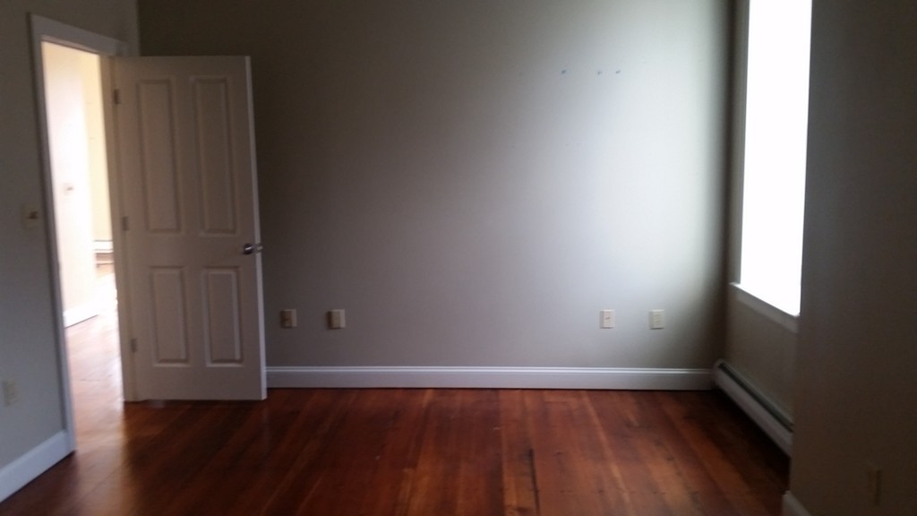 25 Main Street, Unit 3C Ayer, MA 01432 - Photo 5 of 8 a view of an empty room with wooden floor and a window