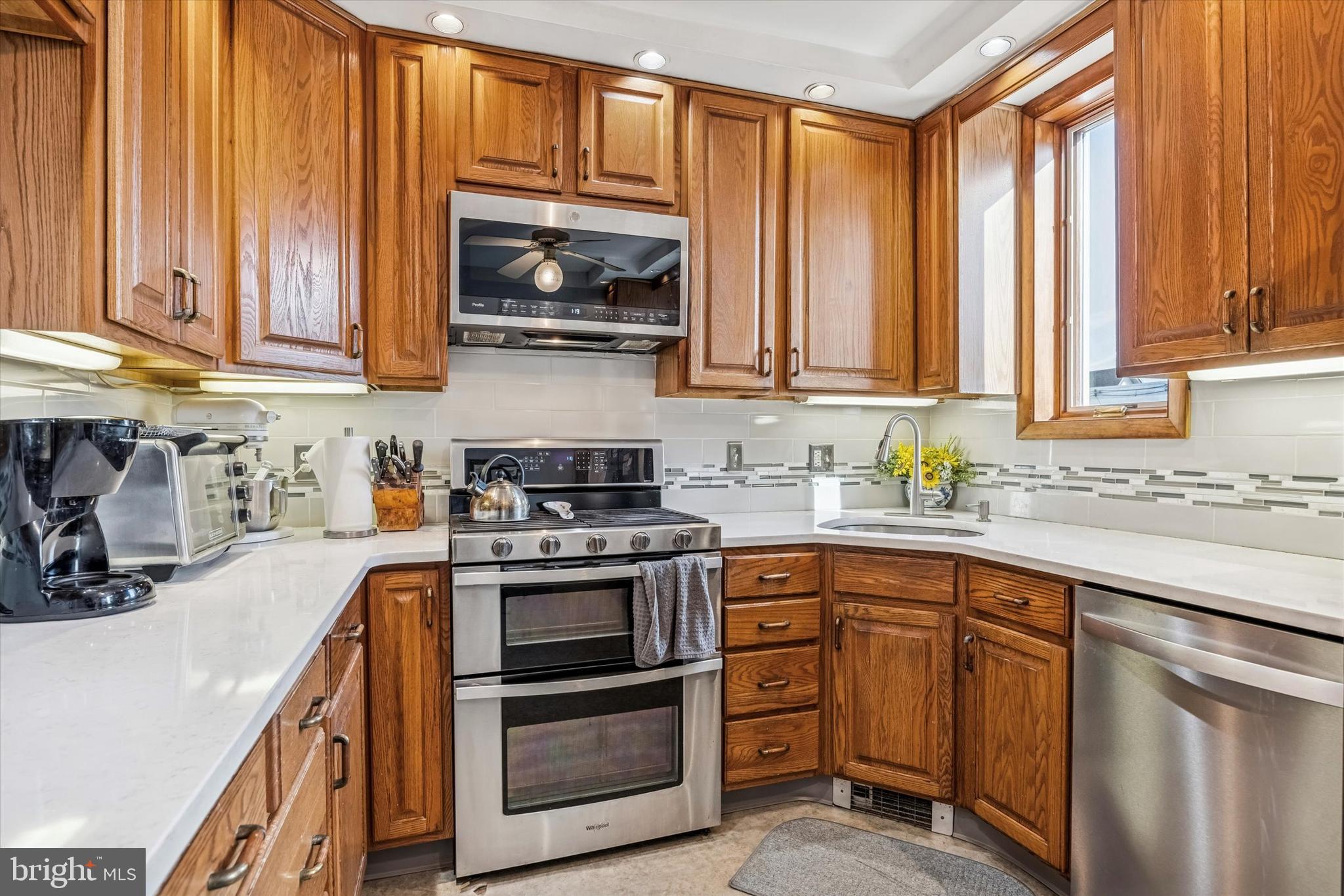 4032 Dayton Road Drexel Hill, PA 19026 - Photo 8 of 22 a kitchen with stainless steel appliances granite countertop a stove a sink and a microwave