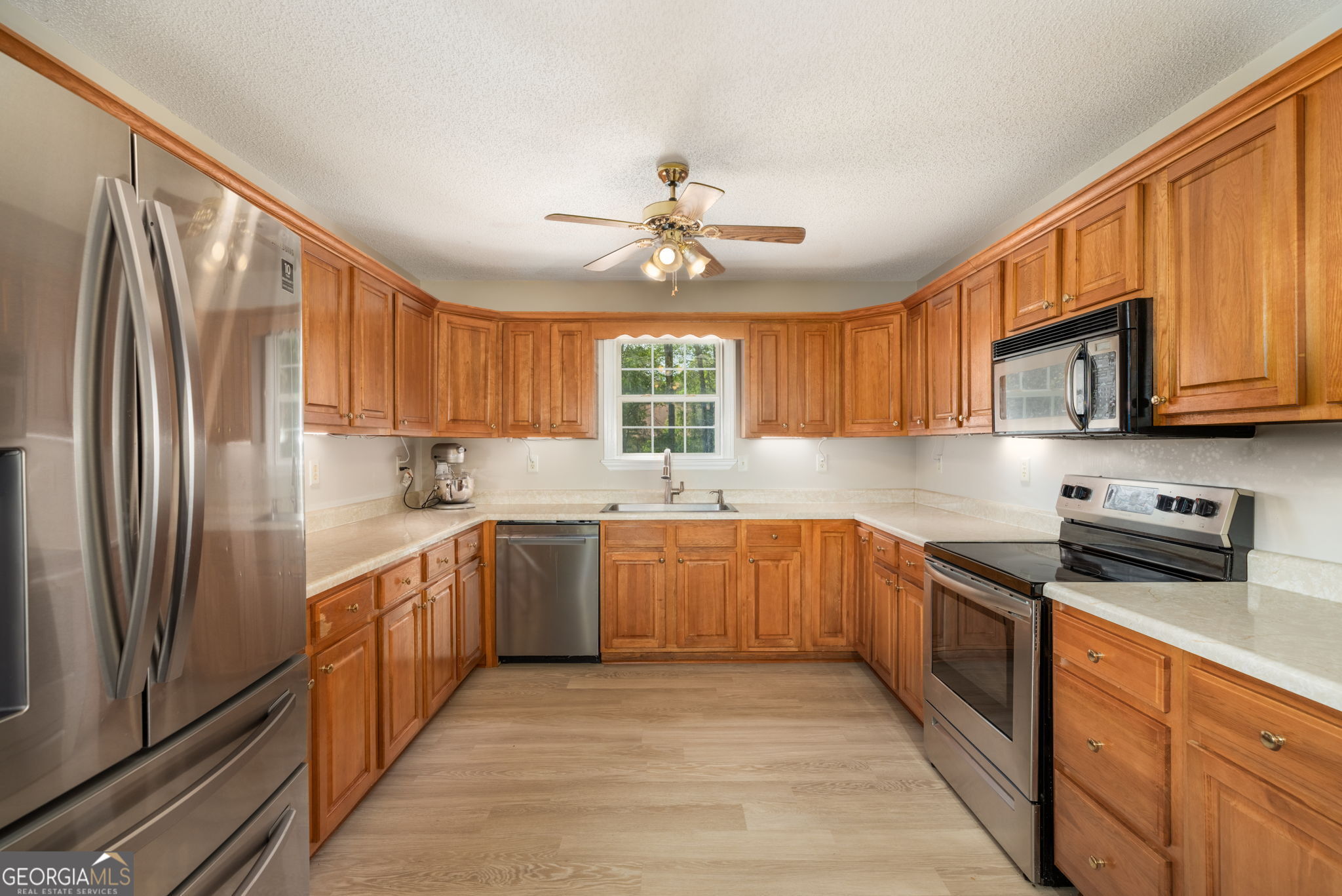 543 Pointe W Drive Dublin, GA 31021 - Photo 12 of 37 a kitchen with stainless steel appliances granite countertop a refrigerator sink stove microwave and cabinets