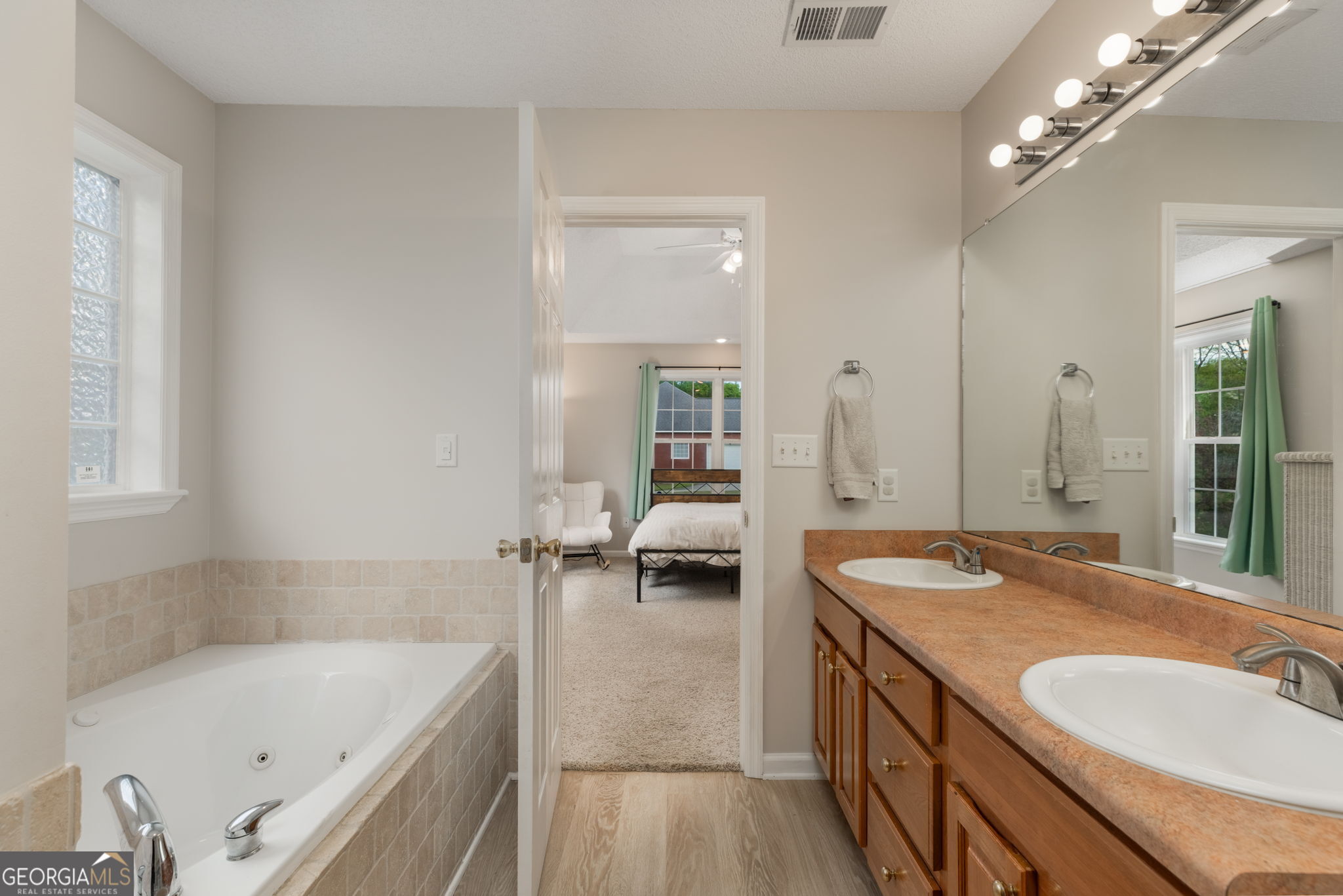 543 Pointe W Drive Dublin, GA 31021 - Photo 21 of 37 a bathroom with a tub a double vanity sink and mirror