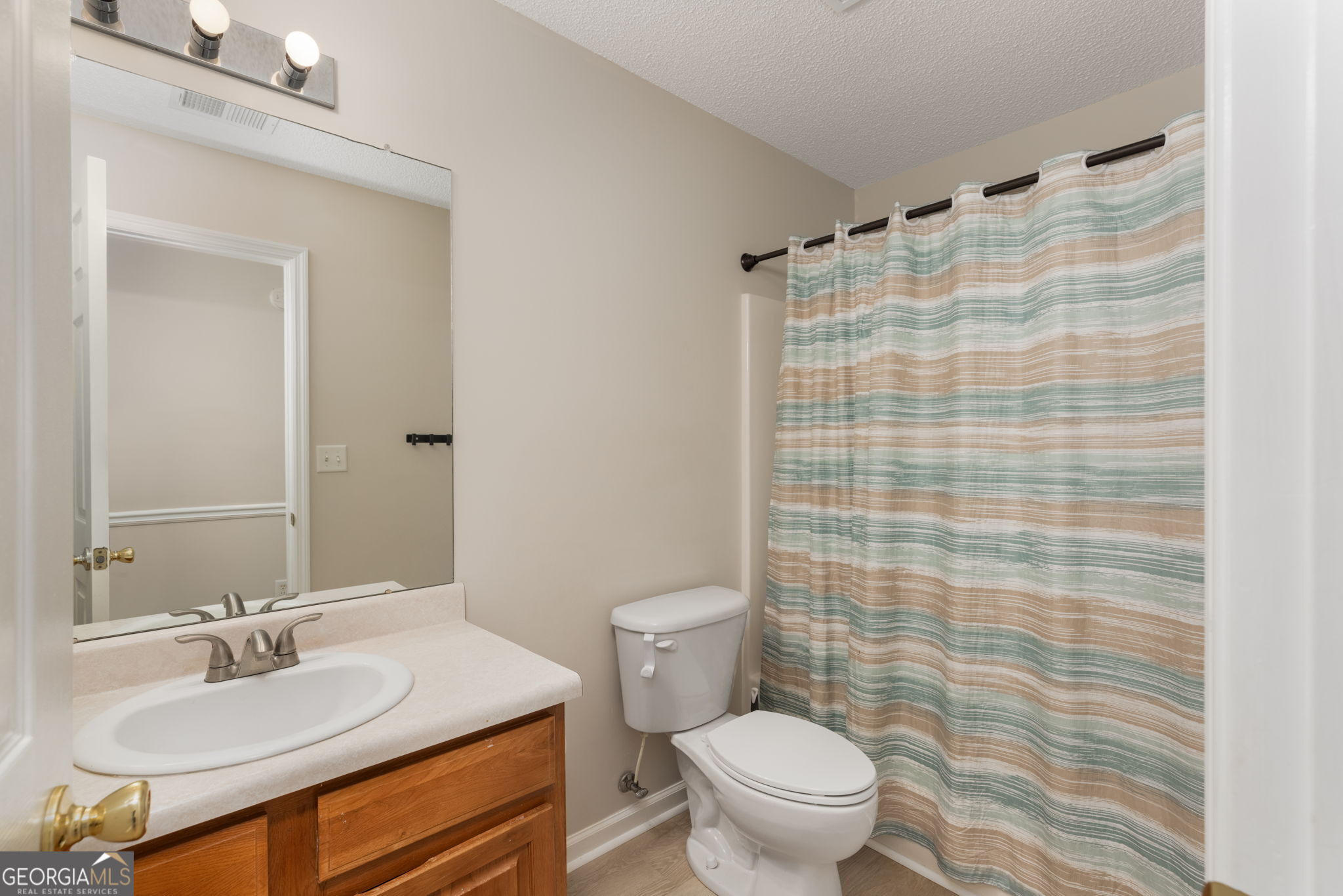 543 Pointe W Drive Dublin, GA 31021 - Photo 28 of 37 a bathroom with a sink a toilet and shower curtain