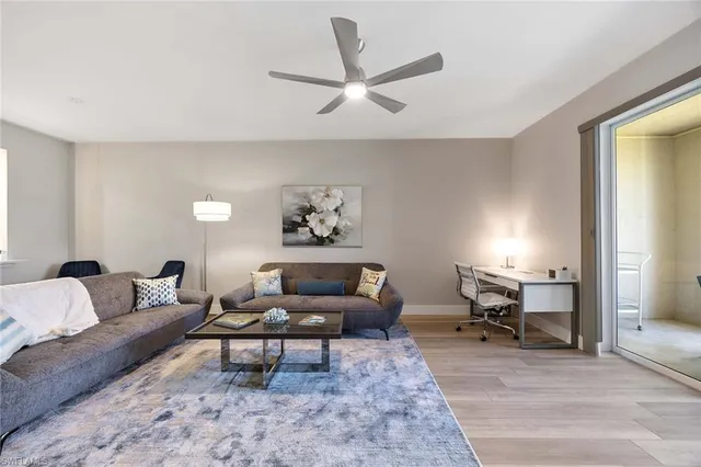 a living room with furniture a rug and a window