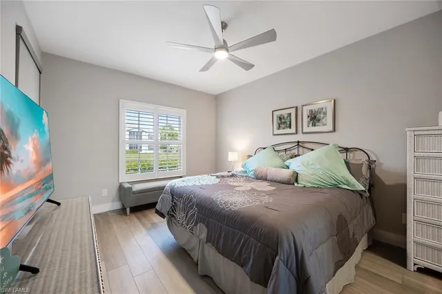 a bedroom with a large bed and a flat tv screen on dresser
