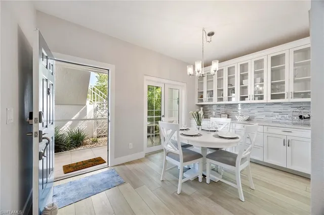 a dining room with furniture a chandelier and wooden floor