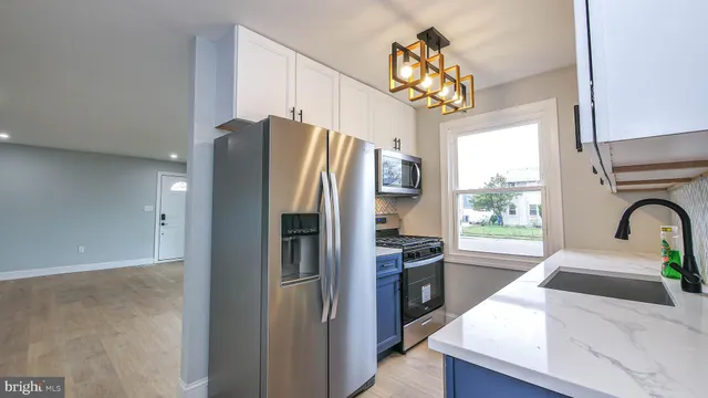 a kitchen with stainless steel appliances granite countertop a refrigerator a sink a stove and a window