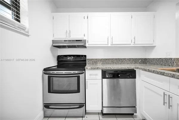 a stove top oven sitting inside of a kitchen