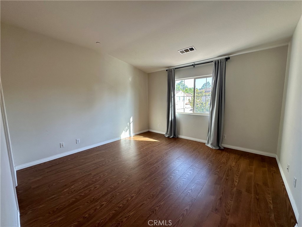 70 Hedge Bloom Irvine, CA 92618 - Photo 18 of 29 an empty room with wooden floor and windows