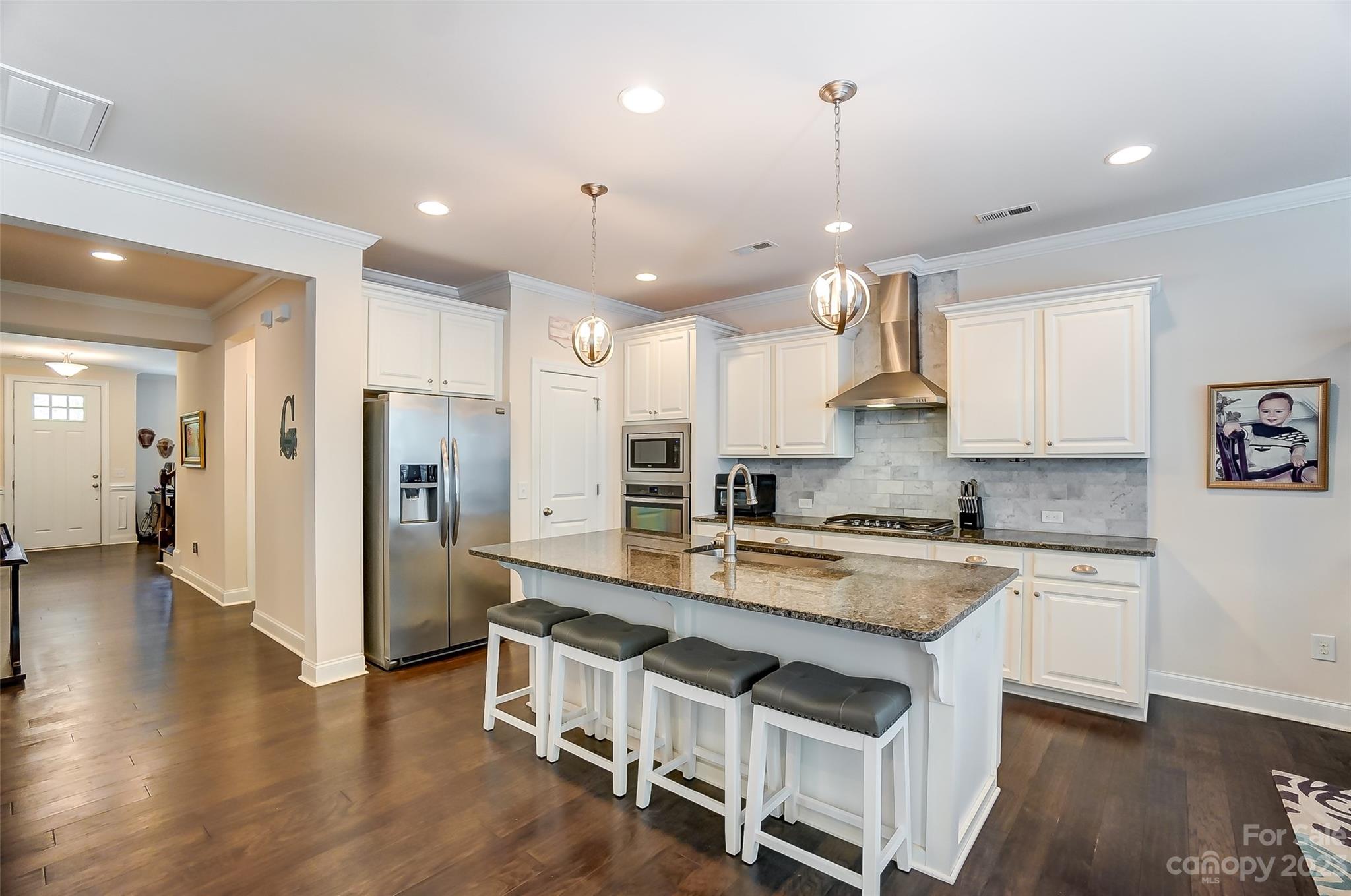 116 Helton Lane Fort Mill, SC 29708 - Photo 13 of 41 a kitchen with stainless steel appliances granite countertop a refrigerator a sink dishwasher a stove and white cabinets with wooden floor