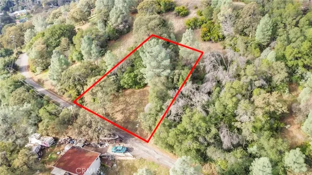 an aerial view of house with yard and mountain view in back