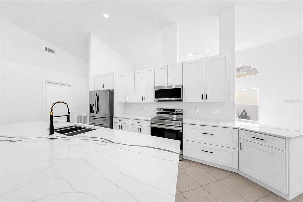 6409 Stone River Road Bradenton, FL 34203 - Photo 20 of 72 a kitchen with white cabinets and appliances