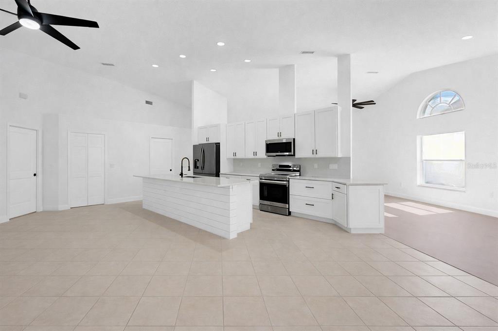 6409 Stone River Road Bradenton, FL 34203 - Photo 22 of 72 a large white kitchen with stainless steel appliances