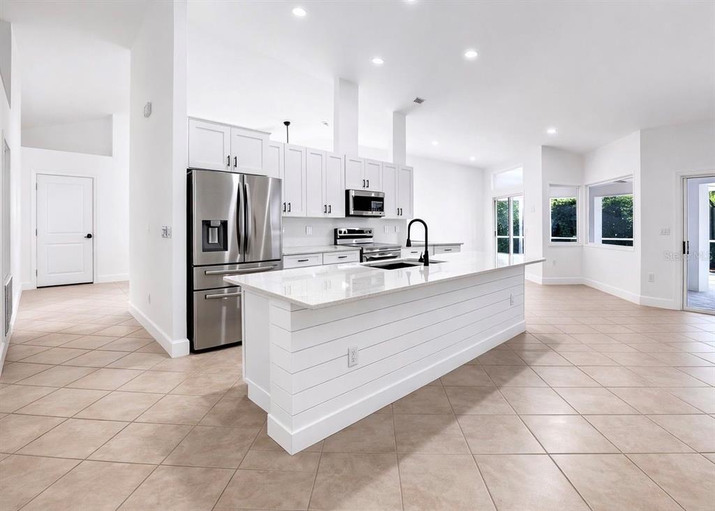 6409 Stone River Road Bradenton, FL 34203 - Photo 25 of 72 a large white kitchen with a large window and stainless steel appliances