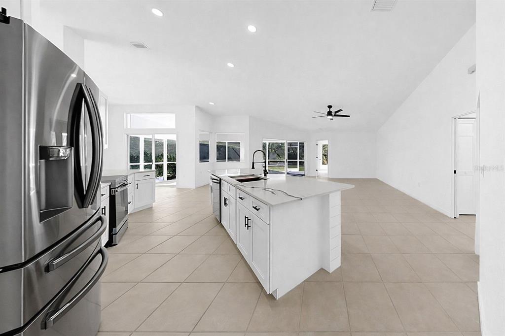 6409 Stone River Road Bradenton, FL 34203 - Photo 29 of 72 a large white kitchen with stainless steel appliances granite countertop a large counter top and a stove