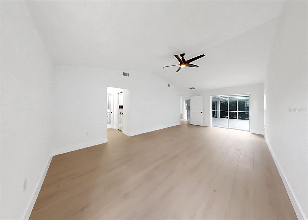 6409 Stone River Road Bradenton, FL 34203 - Photo 39 of 72 an empty room with chandelier fan and windows