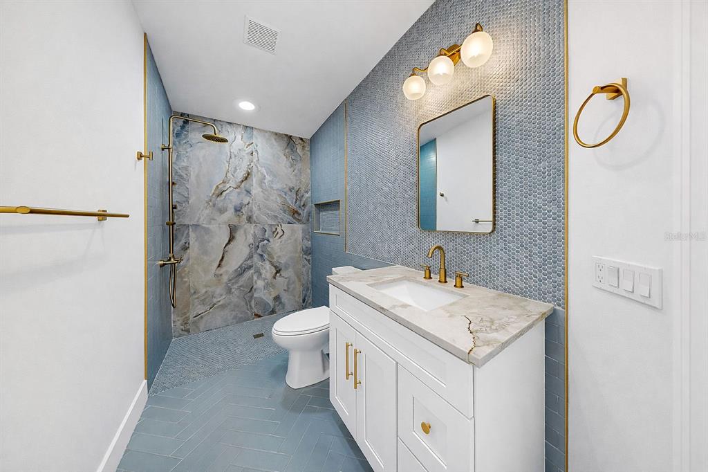 6409 Stone River Road Bradenton, FL 34203 - Photo 57 of 72 a bathroom with a granite countertop sink a toilet and a mirror