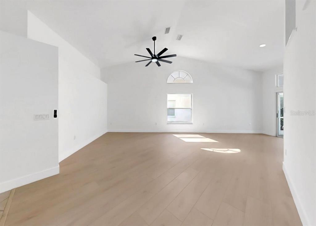 6409 Stone River Road Bradenton, FL 34203 - Photo 10 of 72 an empty room with windows and ceiling fan