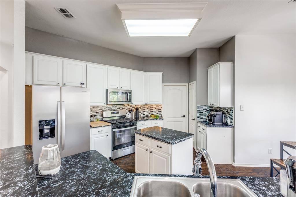 11146 Clearstream Lane Frisco, TX 75035 - Photo 11 of 28 a kitchen with a refrigerator and a stove