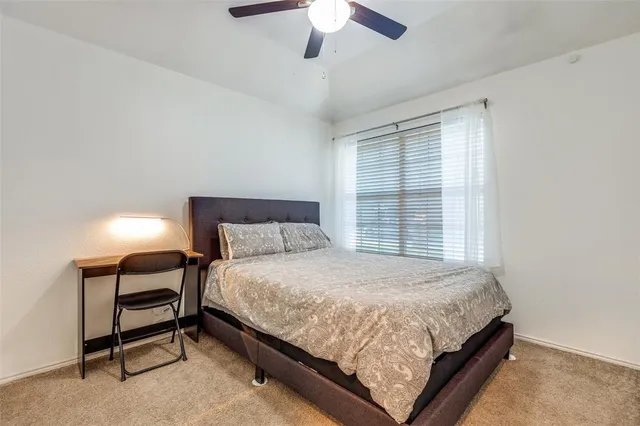 a bedroom with a bed lamp and a window