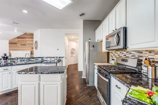 a kitchen with stainless steel appliances granite countertop a stove and a sink