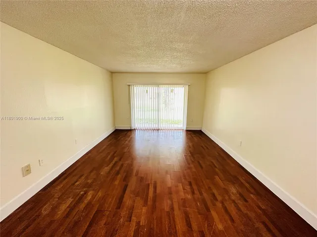 a view of an empty room and wooden floor