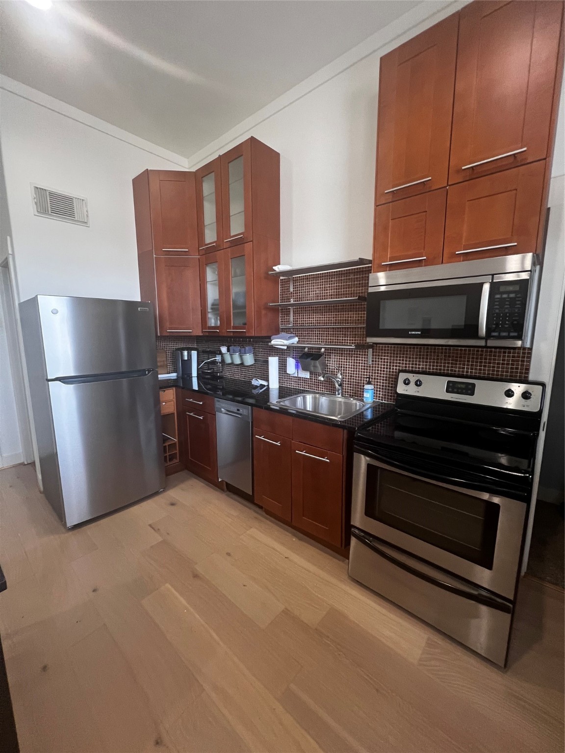 5303 Nett Street, Unit A Houston, TX 77007 - Photo 21 of 23 a kitchen with stainless steel appliances wooden cabinets and a stove