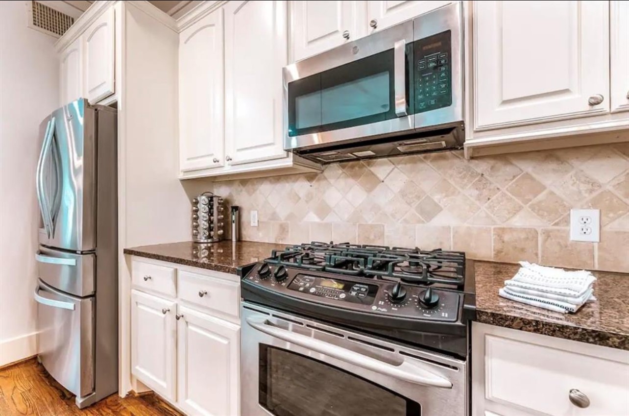 5303 Nett Street, Unit A Houston, TX 77007 - Photo 10 of 23 a kitchen with stainless steel appliances granite countertop a stove and a microwave