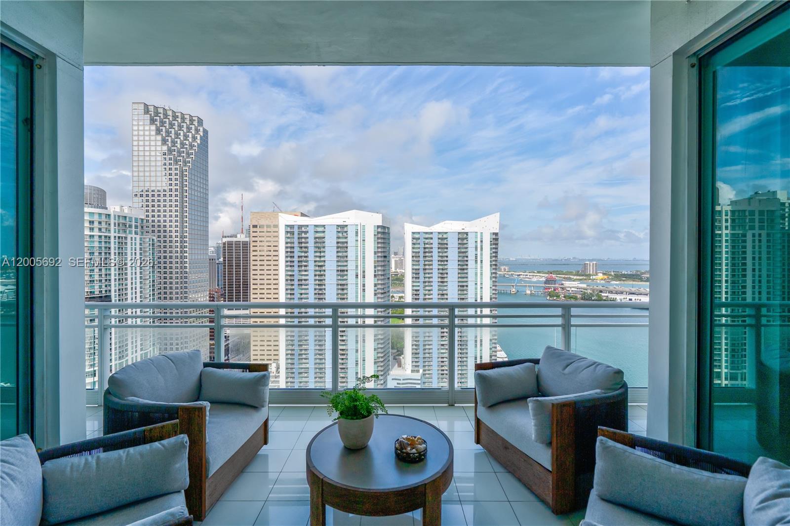 900 Brickell Key Boulevard, Unit 3002 Miami, FL 33131 - Photo 11 of 47 a living room with furniture and a potted plant