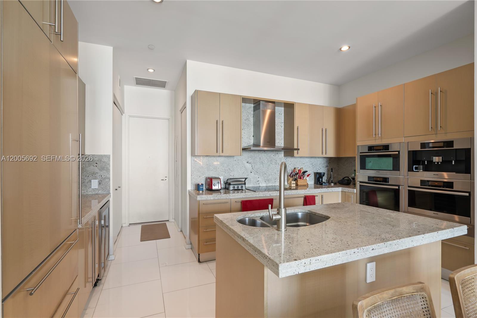 900 Brickell Key Boulevard, Unit 3002 Miami, FL 33131 - Photo 19 of 47 a kitchen with stainless steel appliances granite countertop a sink stove and refrigerator