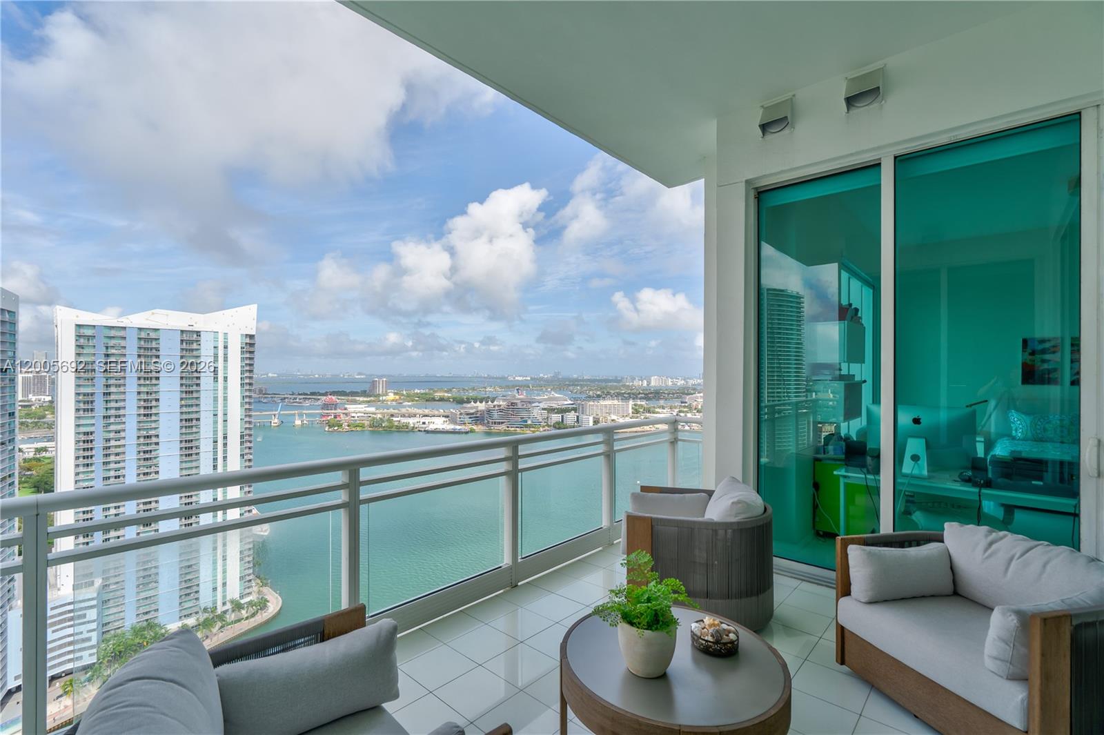 900 Brickell Key Boulevard, Unit 3002 Miami, FL 33131 - Photo 3 of 47 a living room with furniture and a floor to ceiling window