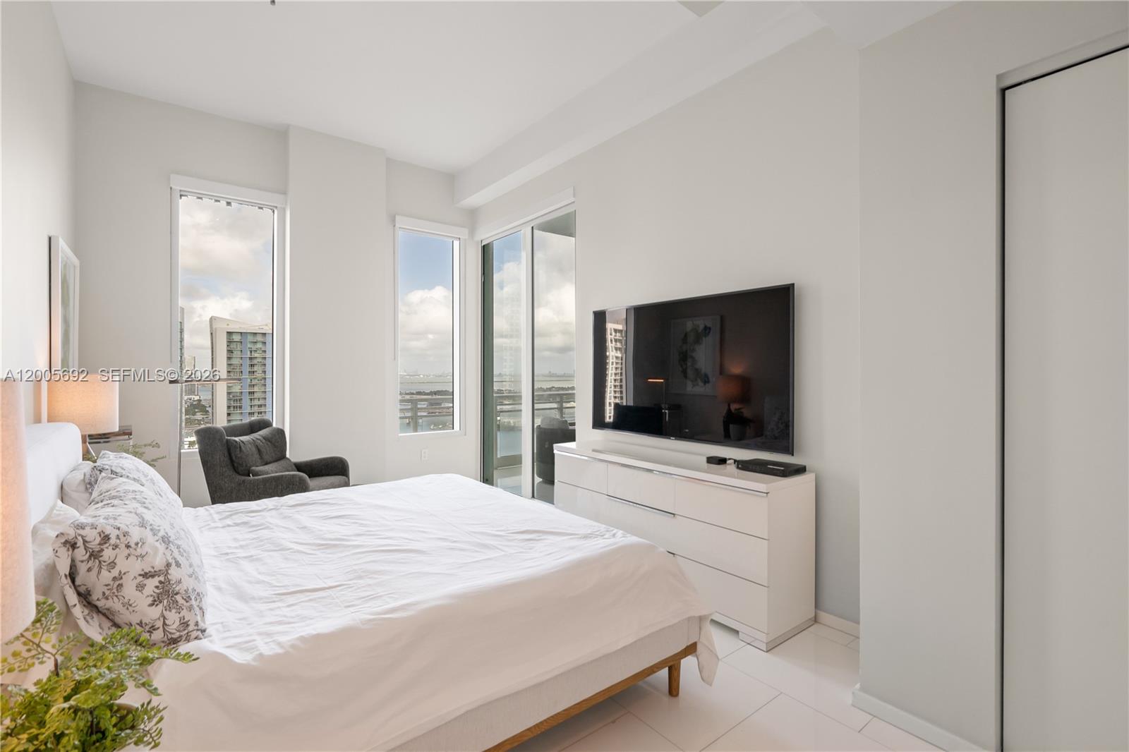 900 Brickell Key Boulevard, Unit 3002 Miami, FL 33131 - Photo 31 of 47 a bedroom with a bed and a flat screen tv