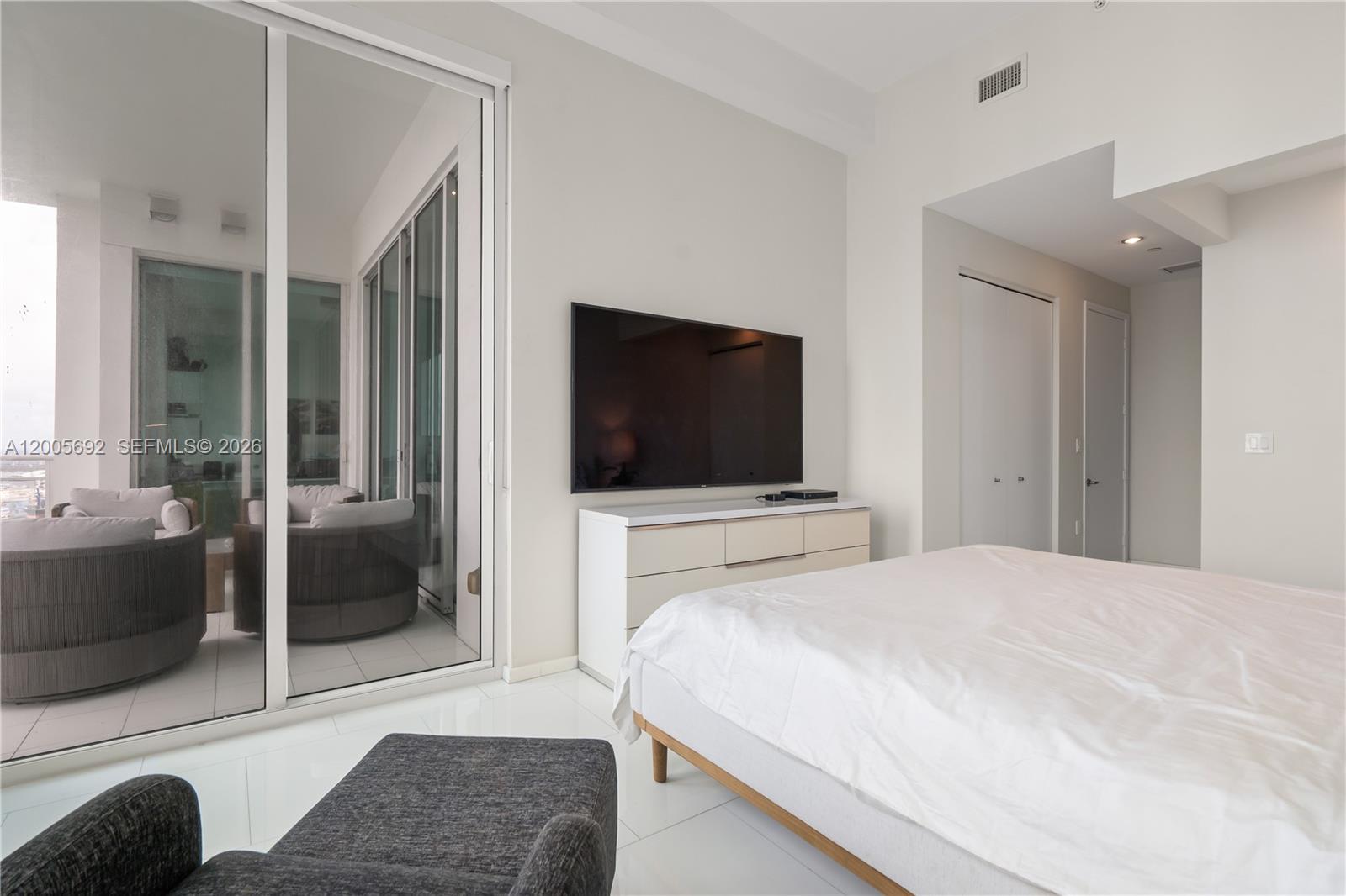 900 Brickell Key Boulevard, Unit 3002 Miami, FL 33131 - Photo 33 of 47 a bedroom with a bed and a flat screen tv